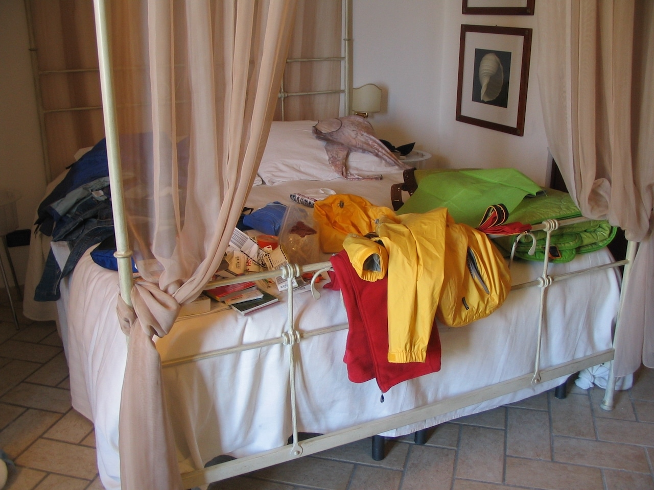 An array of colorful clothes scattered on a bed.